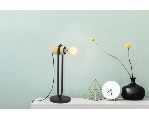 Lampă de masă decorativă din lemn și metal pe o masă