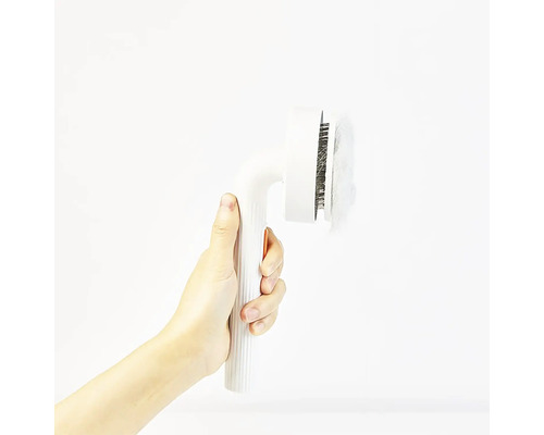 Mână ținând perie de păr pentru animale cu păr de animale