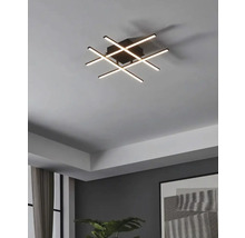 Plafonieră modernă cu bare luminoase LED care se intersectează într-un living.