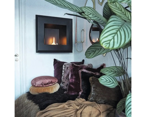 Decor de sufragerie cu șemineu pe bioetanol, perne decorative și plantă de interior