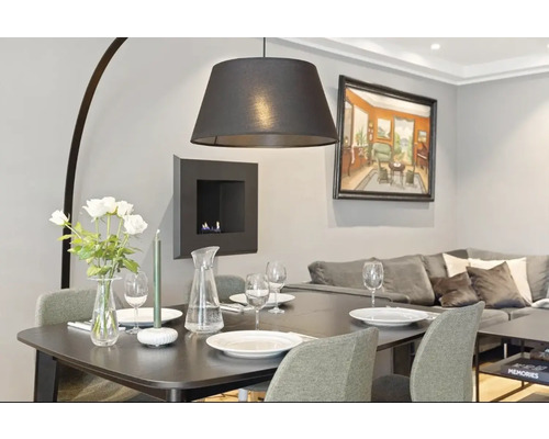 Fotografie de interior a unui living cu masă de sufragerie, scaune, lampă și decorațiuni