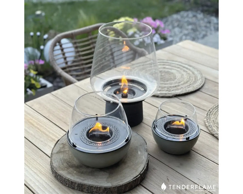 Trei focare de masă Tenderflame pe o masă de lemn afară.