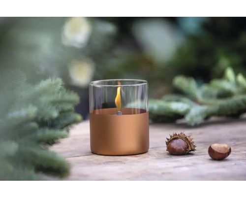 Lampă decorativă cu ulei din sticlă și metal cu castane pe o masă de lemn