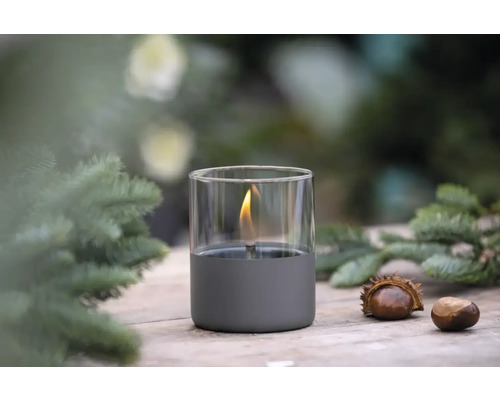 Lampă decorativă cu ulei din sticlă, cu scoarță de copac și castane pe o masă