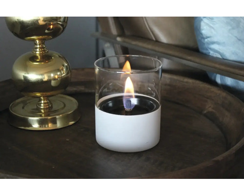 Lampă decorativă cu ulei cu cilindru de sticlă pe o masă