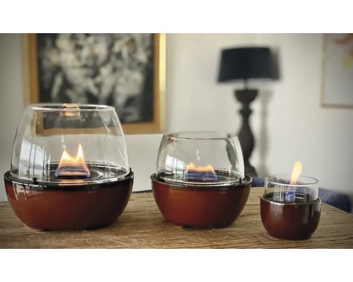 Trei focuri de masă cu bioetanol cu capac de sticlă pe o masă