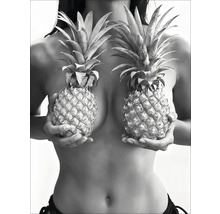 O femeie ține doi ananas în fața pieptului.