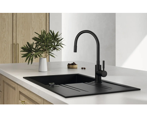 Chiuvetă neagră cu picurător și robinet negru pe un blat de bucătărie.