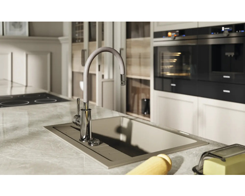 Scenă de bucătărie cu chiuvetă, robinet și aparate de bucătărie.