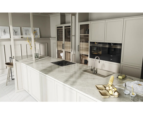 Bucătărie luminoasă cu insulă de gătit, dulapuri încorporate și aparate electrice.