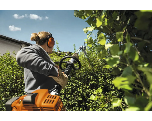 Femeie taie gard viu cu foarfece de gard viu cu rază lungă de acțiune în grădină