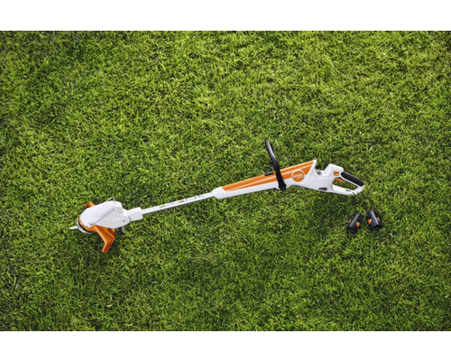 Trimmer de gazon cu acumulator cu două baterii pe gazon