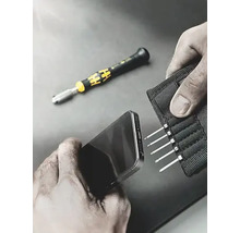Persoană care repară un smartphone cu o șurubelniță și un set de biți pentru șurubelniță