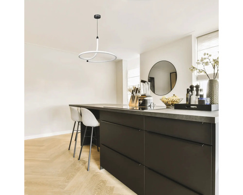 Bucătărie modernă cu insulă de gătit, scaune de bar și o lampă suspendată rotundă.