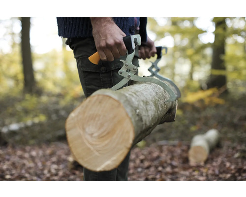 Persoană care transportă un trunchi de copac cu clești de lemn