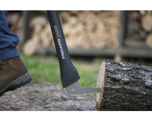 Sigla Fiskars pe un pană de despicat XA22 care despica un buștean.