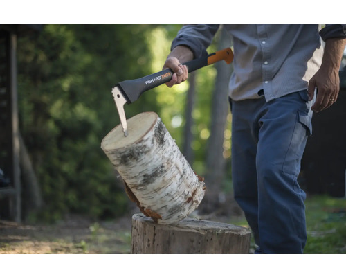 Persoană despărțind un buștean cu un topor Fiskars