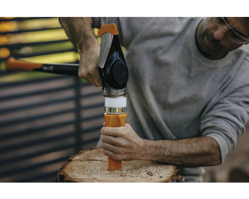 Un bărbat folosește un despicător de lemne pe un buștean