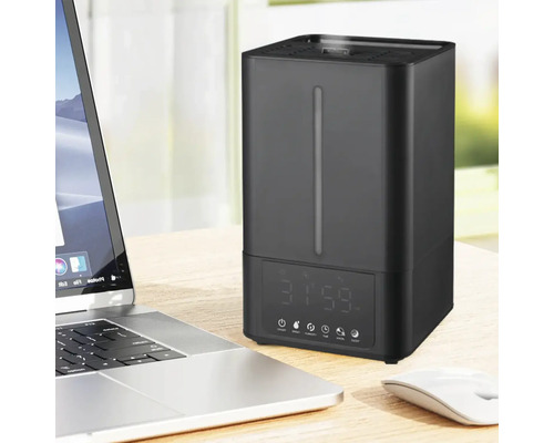 Umidificator lângă un laptop pe o masă