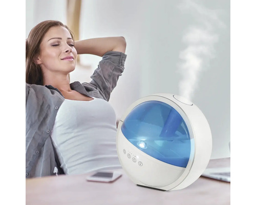 O femeie se relaxează lângă un umidificator de aer pe o masă.