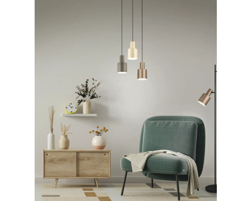 Cameră de zi cu fotoliu, comodă, corpuri de iluminat suspendate și lampă de podea pentru o atmosferă luminoasă și primitoare