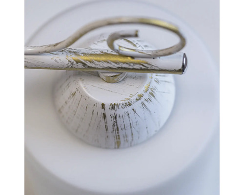 Prim-plan al unei lămpi de perete cu vopsea albă și aurie