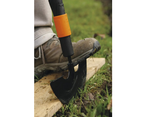 Cazma în uz cu piciorul pe lamă pentru a săpa în grădină.