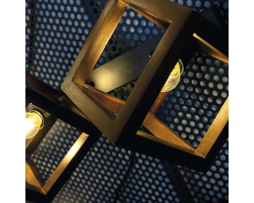 Prim-plan al unei lămpi cu cadru cubic din lemn pe un fundal perforat