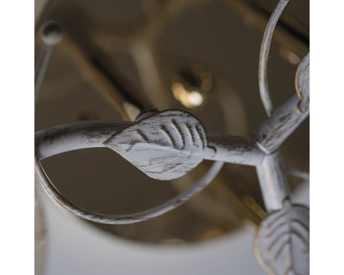 Detaliu al unei lămpi de tavan cu decorațiuni cu frunze