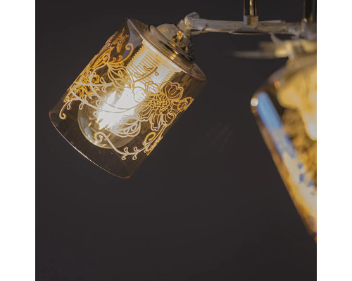 Prim-plan al unei lămpi de plafon cu abajur de sticlă și model floral