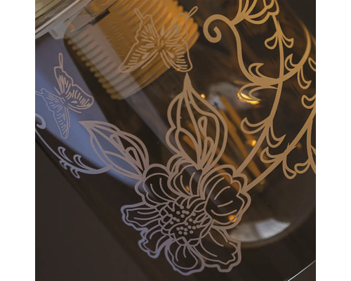 Prim-plan cu un bec cu modele florale și de fluturi