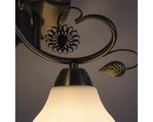 Prim-plan cu o lampă de plafon cu design floral și abajur alb