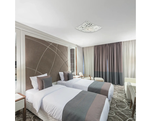 Două paturi într-un dormitor luminos cu plafonieră