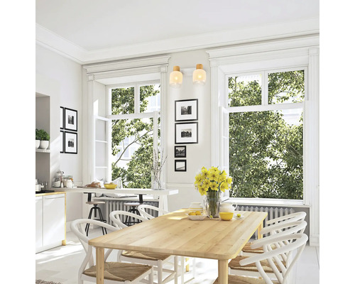 Zonă de luat masa luminoasă cu masă din lemn, scaune albe și ferestre mari