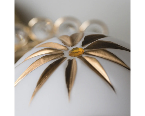 Prim-plan cu un glob de Crăciun alb cu decorațiuni florale aurii