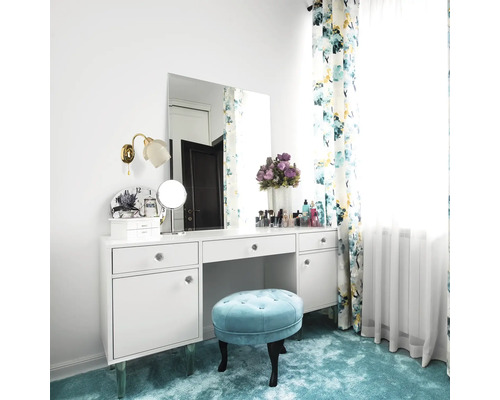 Măsuță de toaletă decorativă cu oglindă, taburet și perdele cu model floral într-o cameră luminoasă.