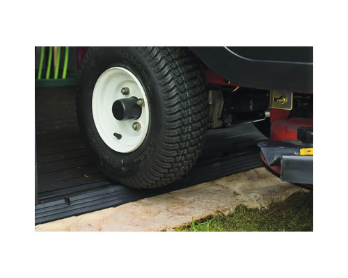 Roata unui tractor de gazon trece peste o rampă