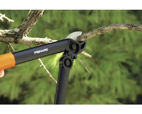 Foarfecă de crengi tăind o creangă cu logo-ul Fiskars