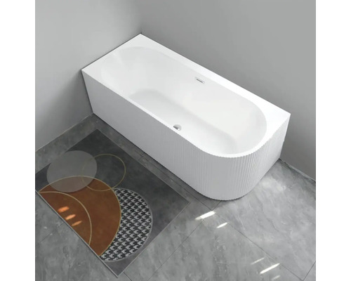 Cadă freestanding în baie cu covoraș de baie cu model pe podea.