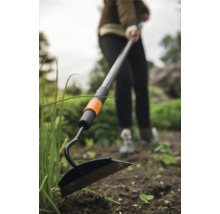 Sapă de grădină cu mâner telescopic utilizată în grădină.