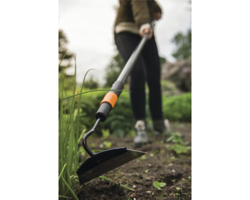 Sapă de grădină cu mâner telescopic utilizată în grădină.