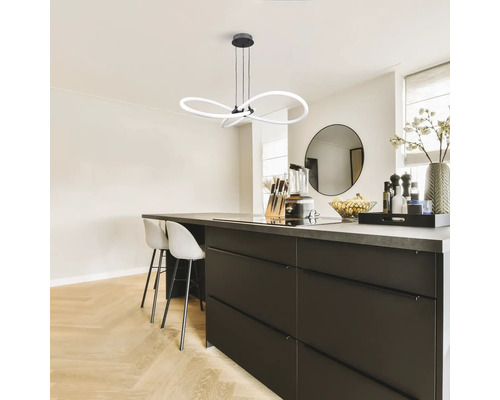 Bucătărie modernă cu masă și lămpi suspendate curbate