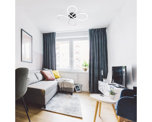 Cameră de zi cu canapea gri, ferestre cu perdele și plafonieră în formă de floare