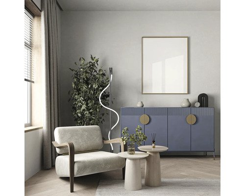 Cameră de zi cu fotoliu, bufet, măsuțe laterale, plantă de interior, lampă de podea și ramă foto