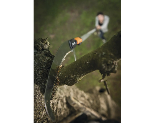 Fierăstrău de grădinărit taie o ramură de copac în grădină