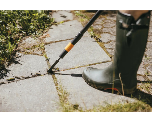 Curățător de rosturi în uz pe pavele cu cizmă de cauciuc