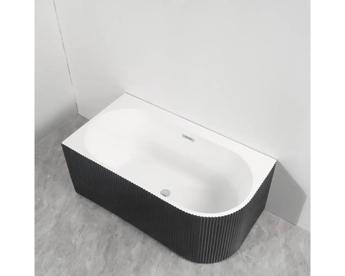 Cadă freestanding cu placare exterioară canelată într-o baie.