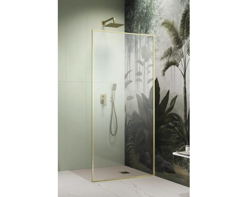 Duș Walk In Radaway Modo F, 90x200 cm, sticlă transparentă, profil auriu Cabină de duș cu cadru auriu, duș fix și duș mobil în fața unui tapet de perete cu tematică de junglă