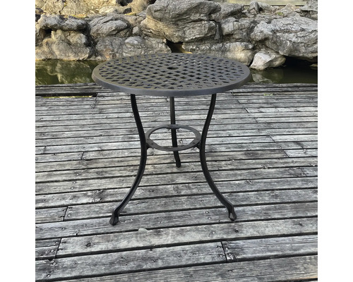 Măsuță rotundă de grădină din metal pe terasă de lemn