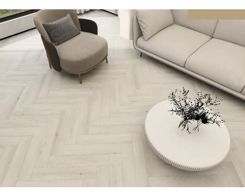 Cameră de zi luminoasă cu parchet herringbone, fotoliu, canapea și masă